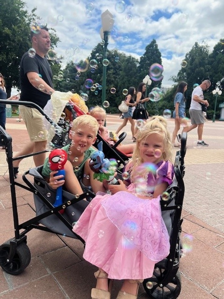 Twee kinderen in een bolderkar met zeepbellen in Disneyland Paris
