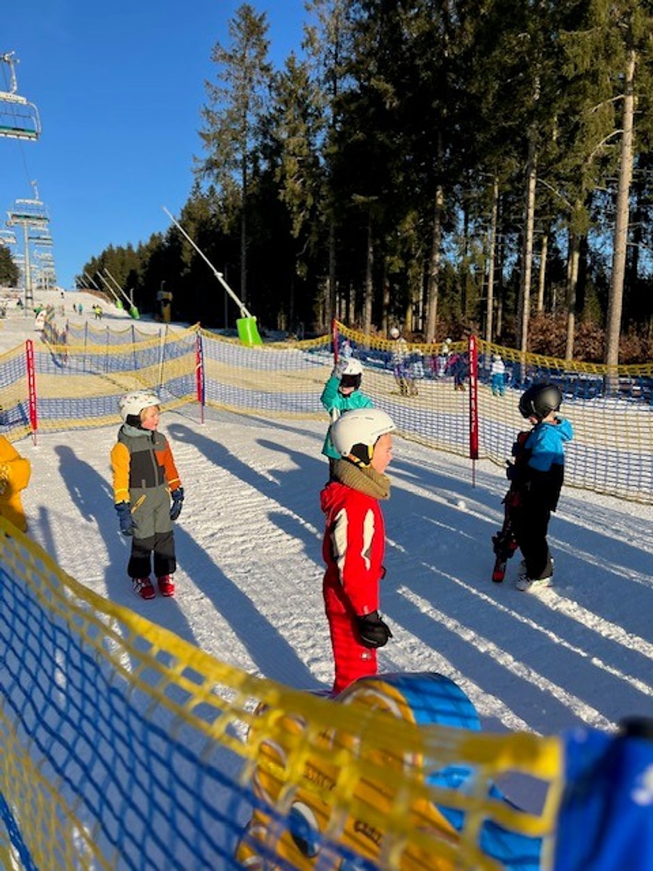 Kinderen leren skien op een oefenpiste van een skischool in Winterberg